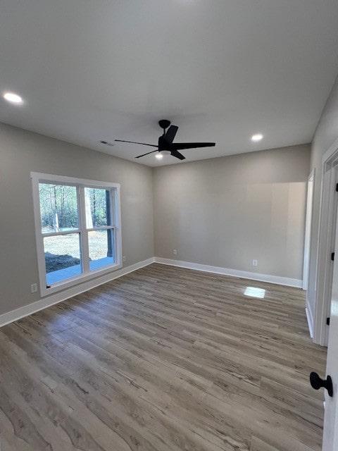 spare room with ceiling fan and light wood-type flooring