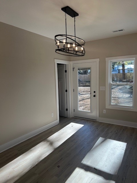 entryway featuring a chandelier, a healthy amount of sunlight, and dark hardwood / wood-style floors