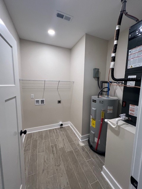 laundry room featuring hardwood / wood-style flooring, electric dryer hookup, electric water heater, and washer hookup