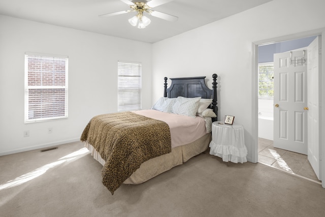 bedroom with light carpet, multiple windows, and ceiling fan