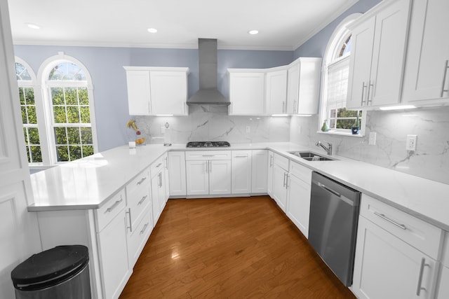 kitchen featuring white cabinetry, wall chimney range hood, appliances with stainless steel finishes, and plenty of natural light