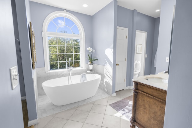 bathroom featuring vanity, tile walls, a washtub, and tile patterned flooring