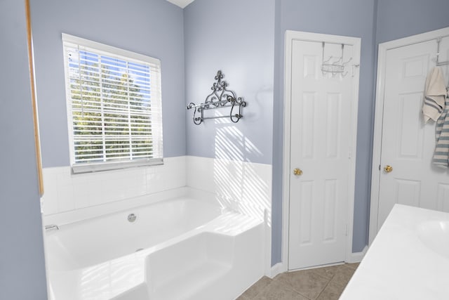 bathroom with vanity, tile patterned floors, and a bath