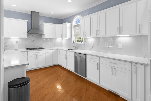 kitchen with decorative backsplash, wall chimney exhaust hood, white cabinetry, and stainless steel appliances