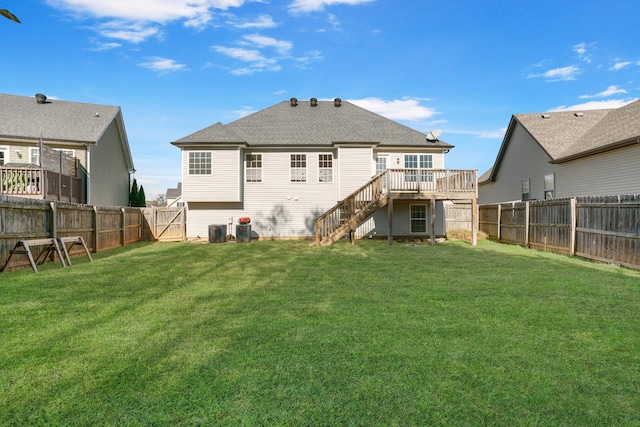 rear view of property featuring central air condition unit, a deck, and a lawn