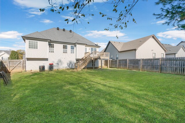 back of house featuring a wooden deck and a yard