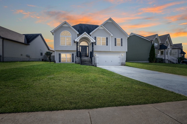 split foyer home with a yard and a garage