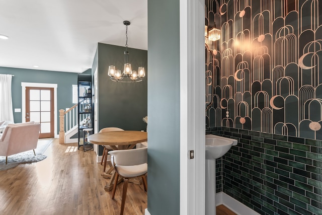 bathroom featuring an inviting chandelier, tile walls, and hardwood / wood-style flooring