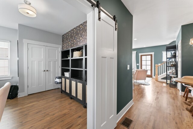 hall featuring hardwood / wood-style floors and a barn door