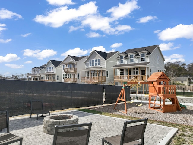 view of patio with a playground and an outdoor fire pit