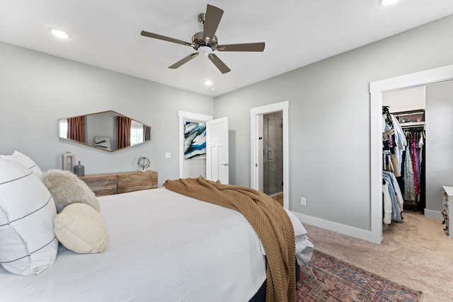 carpeted bedroom with ceiling fan, a walk in closet, connected bathroom, and a closet