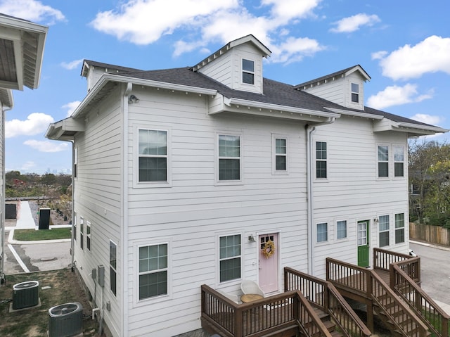 back of house featuring central AC unit and a wooden deck