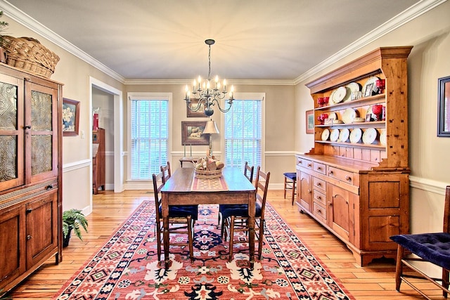 dining space featuring light hardwood / wood-style flooring, ornamental molding, and a notable chandelier