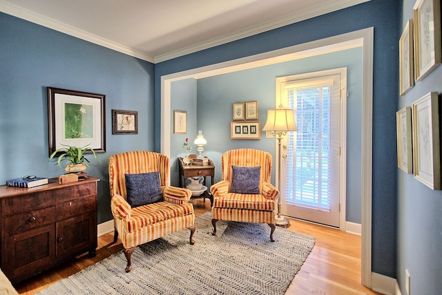 sitting room featuring crown molding and light wood-type flooring