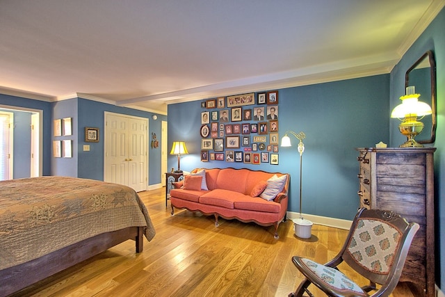 bedroom with crown molding, wood-type flooring, and a closet