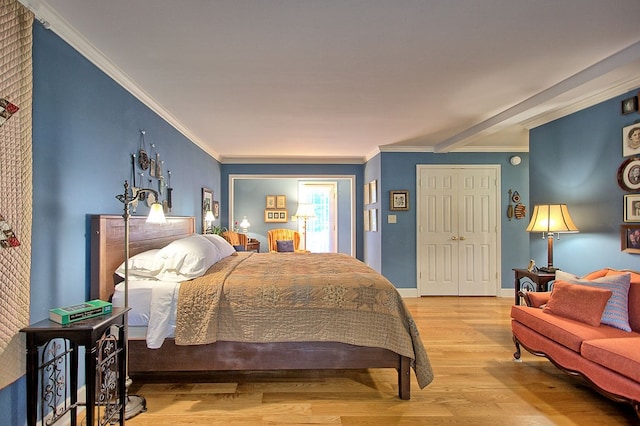 bedroom with ornamental molding, light hardwood / wood-style flooring, and a closet