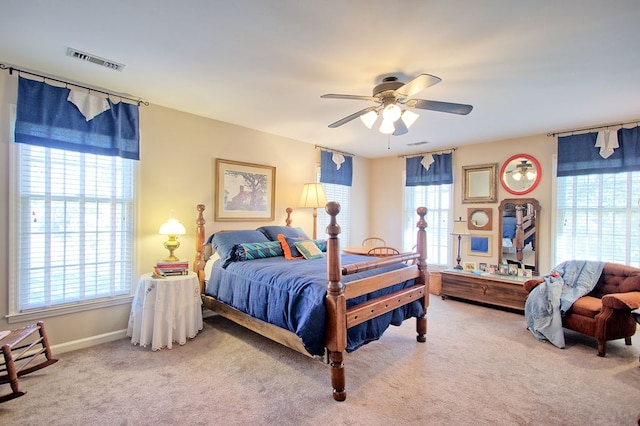 carpeted bedroom with multiple windows and ceiling fan