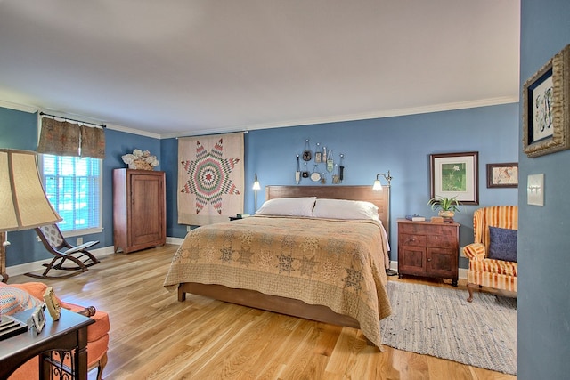 bedroom with light hardwood / wood-style floors and ornamental molding