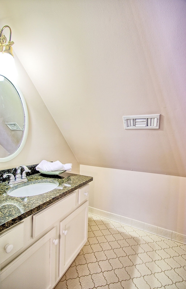 bathroom with vanity and lofted ceiling