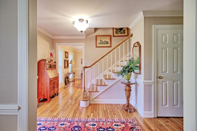 entryway featuring crown molding and light wood-type flooring