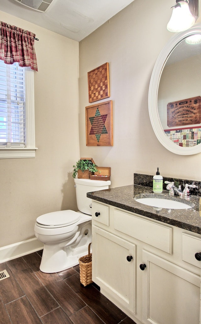 bathroom with vanity, toilet, and hardwood / wood-style floors