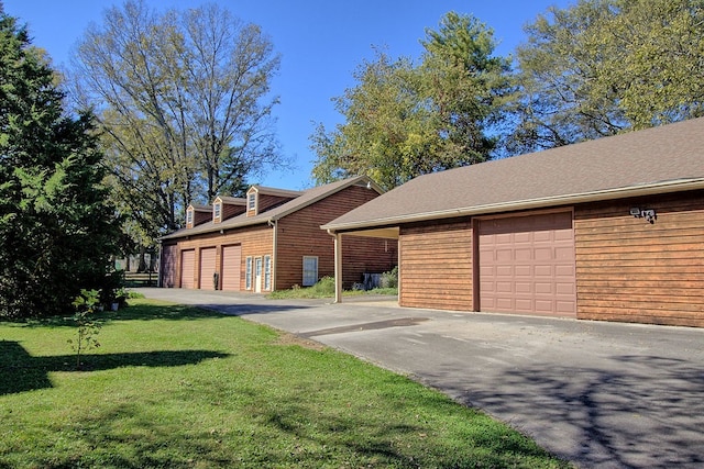 view of front of home featuring a front yard, a garage, and an outdoor structure