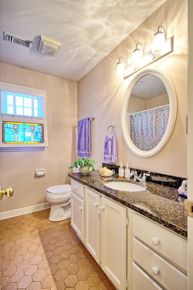 bathroom with vanity, toilet, and tile patterned flooring