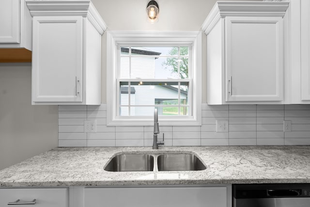 kitchen featuring white cabinets, dishwasher, light stone counters, and sink