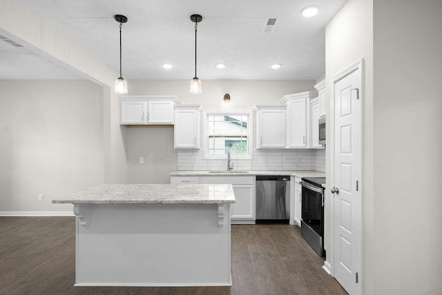 kitchen with a center island, sink, stainless steel appliances, pendant lighting, and white cabinets