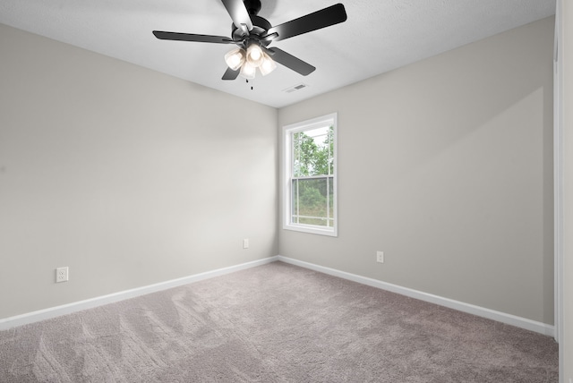 unfurnished room with ceiling fan and carpet