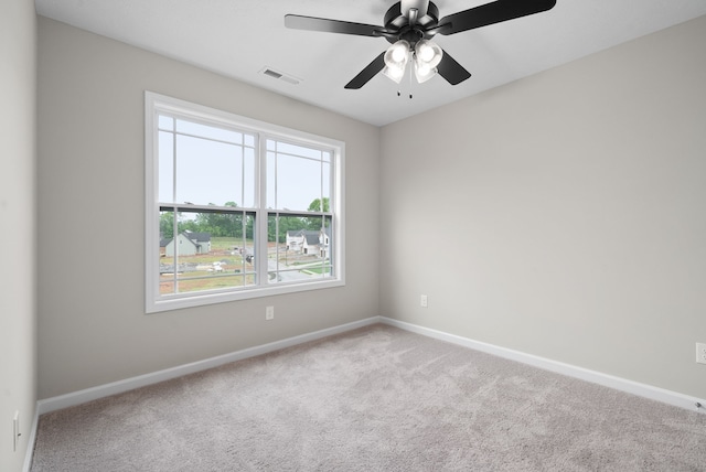 carpeted empty room featuring ceiling fan and a wealth of natural light