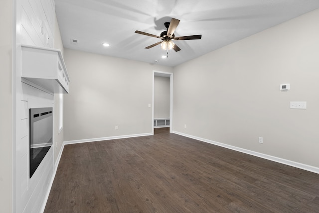 unfurnished living room featuring dark hardwood / wood-style flooring and ceiling fan