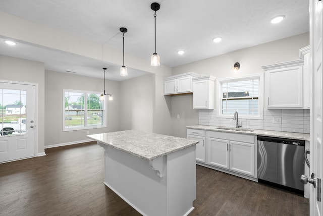 kitchen with dishwasher, white cabinets, sink, hanging light fixtures, and dark hardwood / wood-style floors