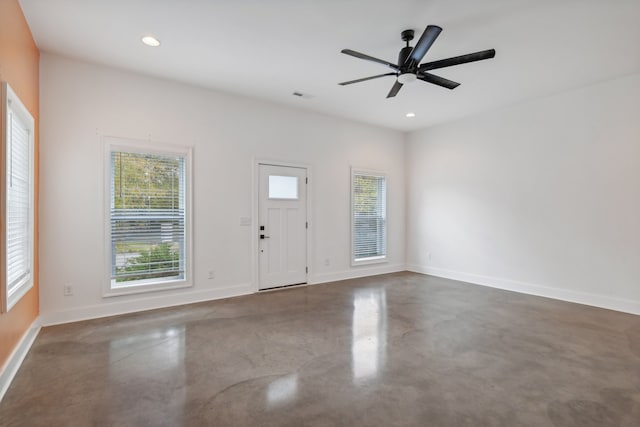 entryway with ceiling fan and concrete flooring