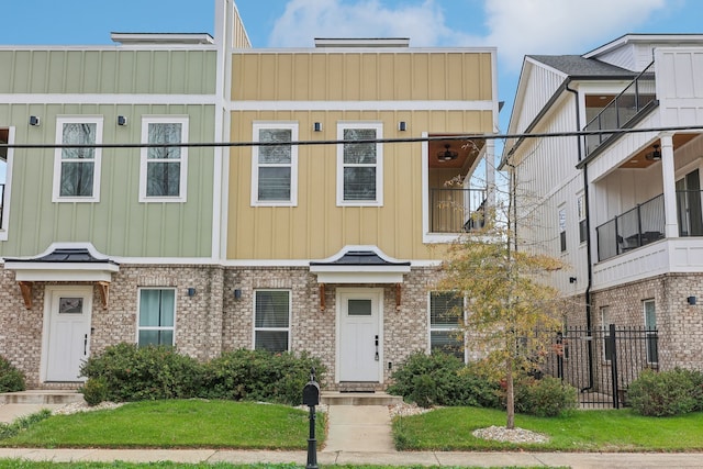 multi unit property with a front yard and a balcony