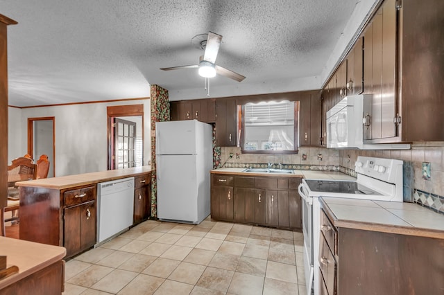 kitchen featuring white appliances, decorative backsplash, sink, and dark brown cabinetry