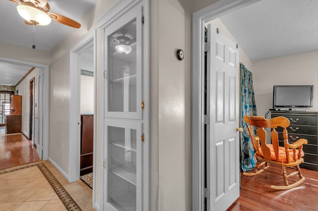 hall with a textured ceiling and light hardwood / wood-style floors