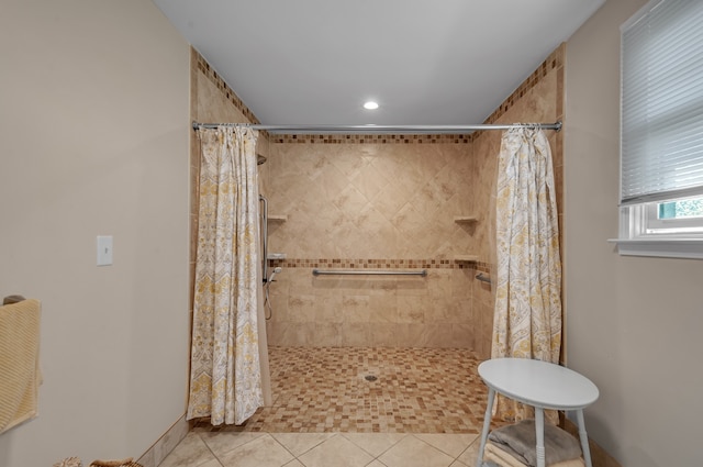 bathroom with curtained shower and tile patterned flooring