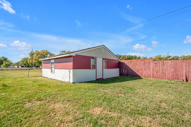 view of side of home with a shed and a yard