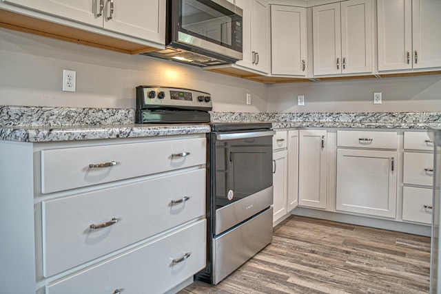 10309 Goff Ridge Rd, Baxter, TN 38544 - kitchen featuring stainless steel appliances, light wood-style floors, white cabinets, and light stone counters