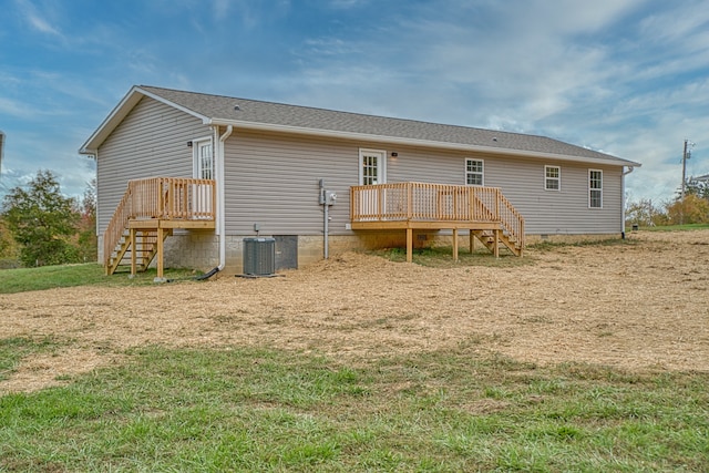 back of property featuring a deck, central air condition unit, and a lawn