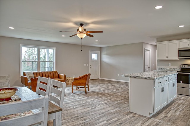 10309 Goff Ridge Rd, Baxter, TN 38544 - kitchen with stainless steel appliances, ceiling fan, light wood-style flooring, white cabinetry, and recessed lighting