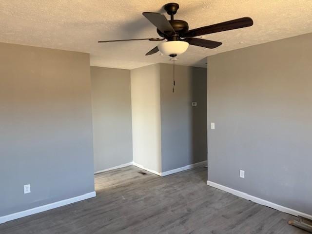 spare room with a textured ceiling, dark hardwood / wood-style flooring, and ceiling fan