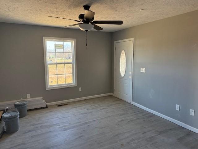 foyer with ceiling fan, light wood-type flooring, and a textured ceiling