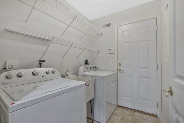 laundry room featuring independent washer and dryer and light tile patterned flooring