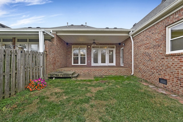 exterior space featuring ceiling fan and a lawn