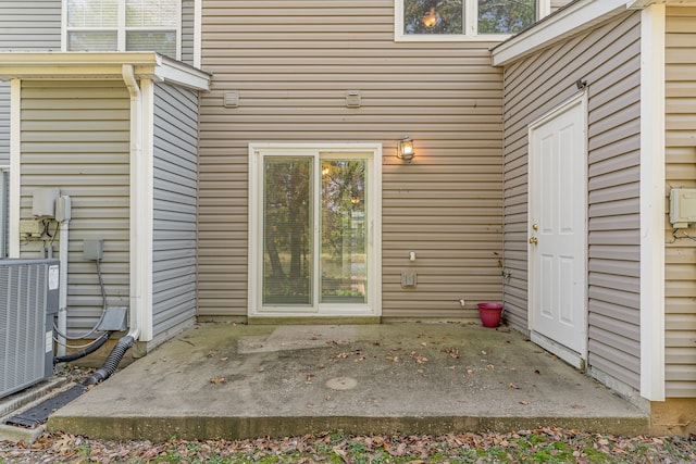 doorway to property with central air condition unit and a patio area