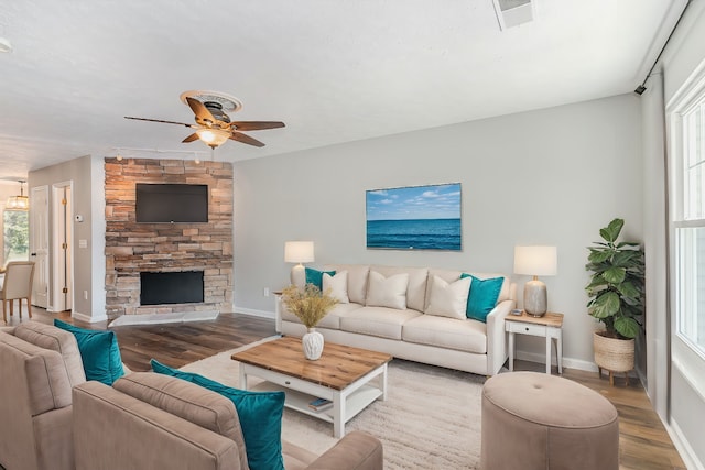 living room with a fireplace, light hardwood / wood-style floors, and ceiling fan