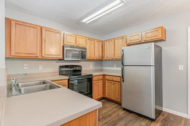 kitchen featuring sink, appliances with stainless steel finishes, dark hardwood / wood-style floors, and a textured ceiling