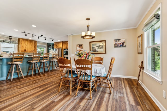 dining area featuring crown molding, a notable chandelier, and dark hardwood / wood-style floors